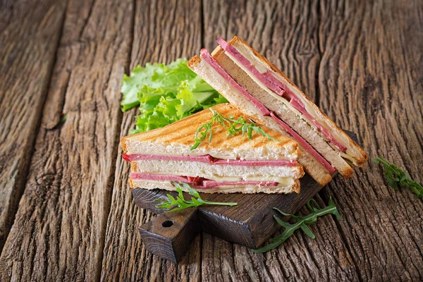 Club sandviç - panini jambon ve peynir ahşap arka plan üzerinde. Piknik gıda.