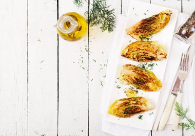 Vegan üstten görünüm Beyaz ahşap zemin üzerinde lahana biftek ızgara. 