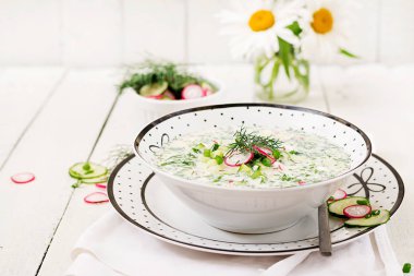 Ahşap arka plan üzerinde taze salatalık, turp, kase yoğurt ile soğuk çorbasına görünümü Kapat.