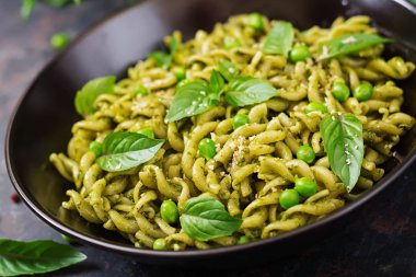 Düdük makarna pesto sosu, yeşil bezelye ve fesleğen ile görünümü Kapat.
