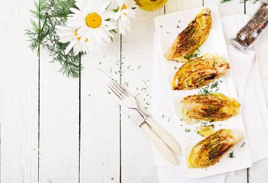 Vegan üstten görünüm Beyaz ahşap zemin üzerinde lahana biftek ızgara. 