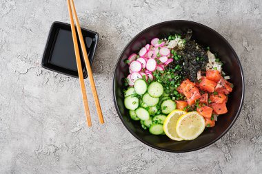 Hawaiian Somon Balık poke kase pirinç, turp, salatalık, domates, susam ve yosunlar. Buda kase. Diyet yemekleri. Üstten görünüm. Düz yatıyordu