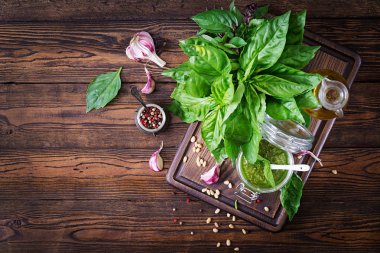 Ev yapımı pesto sos taze fesleğen, çam fıstığı ve ahşap zemin üzerine sarımsak. İtalyan yemeği. Üstten görünüm kopya alanı ile. Düz yatıyordu