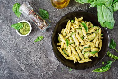 Pesto sos, kabak, yeşil bezelye ve fesleğen ile penne makarna. İtalyan yemeği. Üstten görünüm. Düz kopya alanı ile yatıyordu