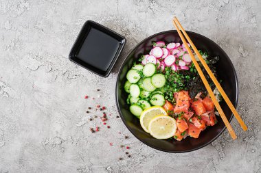 Hawaiian Somon Balık poke kase pirinç, turp, salatalık, domates, susam ve yosunlar. Buda kase. Diyet yemekleri. Üstten görünüm. Düz yatıyordu