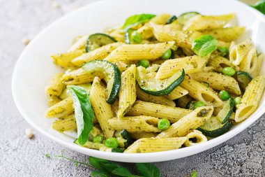 plaka pesto sos, kabak, yeşil bezelye ve fesleğen ile penne makarna ile yakın çekim