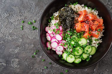 Hawaiian Somon Balık poke kase pirinç, turp, salatalık, domates, susam ve yosunlar. Buda kase. Diyet yemekleri. Üstten görünüm. Düz yatıyordu