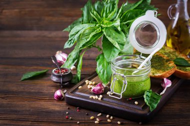 Ev yapımı pesto sos taze fesleğen, çam fıstığı ve ahşap zemin üzerine sarımsak. Italyan Mutfagi.