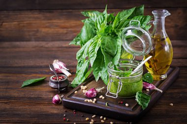 Ev yapımı pesto sos taze fesleğen, çam fıstığı ve ahşap zemin üzerine sarımsak. Italyan Mutfagi.