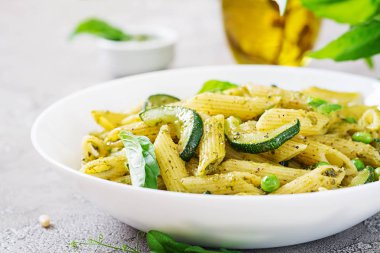 plaka pesto sos, kabak, yeşil bezelye ve fesleğen ile penne makarna ile yakın çekim