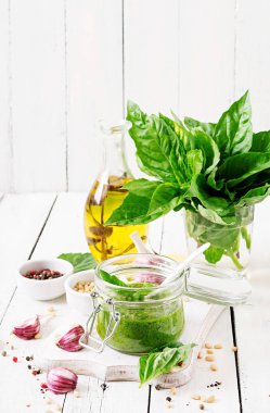 Ev yapımı pesto sos taze fesleğen, çam fıstığı ve sarımsak Beyaz ahşap zemin üzerinde. Italyan Mutfagi.