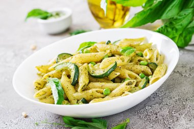 plaka pesto sos, kabak, yeşil bezelye ve fesleğen ile penne makarna ile yakın çekim