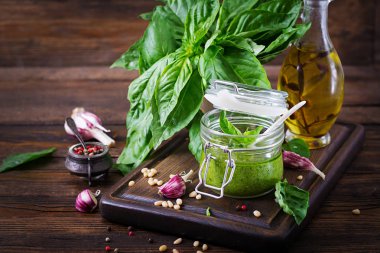 Ev yapımı pesto sos taze fesleğen, çam fıstığı ve ahşap zemin üzerine sarımsak. Italyan Mutfagi.