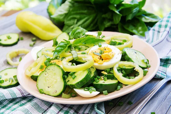 Breakfast in the summer garden. Salad of eggs and cucumbers with green onions and basil.