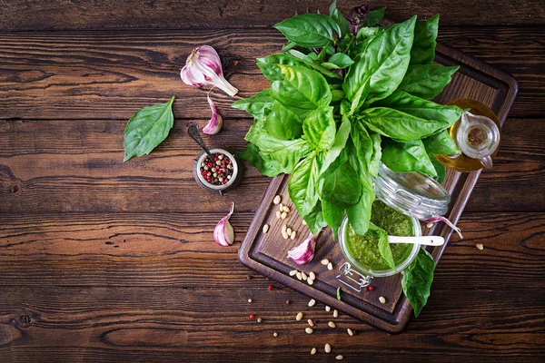 Ev yapımı pesto sos taze fesleğen, çam fıstığı ve ahşap zemin üzerine sarımsak. İtalyan yemeği. Üstten görünüm kopya alanı ile. Düz yatıyordu