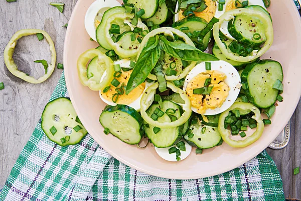 Breakfast in the summer garden. Salad of eggs and cucumbers with green onions and basil. Top view. Flat lay