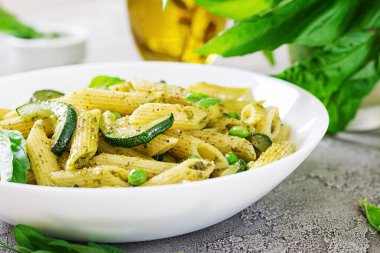 plaka pesto sos, kabak, yeşil bezelye ve fesleğen ile penne makarna ile yakın çekim