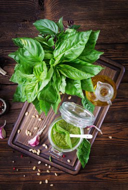 Ev yapımı pesto sos taze fesleğen, çam fıstığı ve ahşap zemin üzerine sarımsak. İtalyan yemeği. Üstten görünüm.