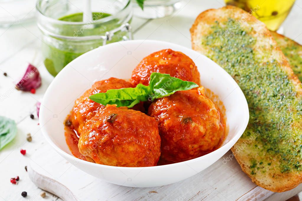 Meatballs in tomato sauce and toast with basil pesto. Dinner. Tasty food.
