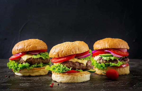 Tres Hamburguesas Con Carne Res Verduras Frescas Sobre Fondo Oscuro —  Fotos de Stock