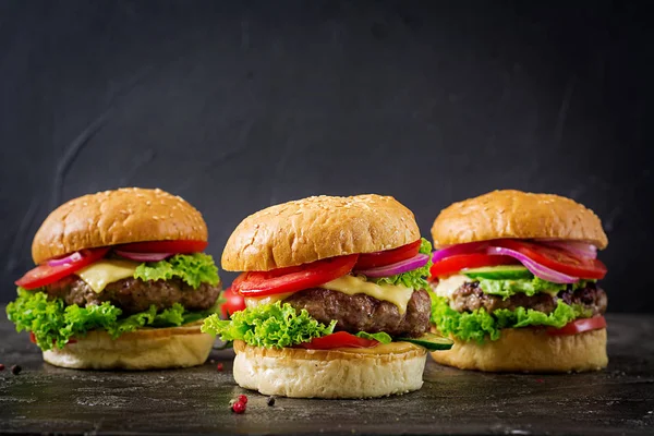 三汉堡包与牛肉和新鲜蔬菜在黑暗的背景与拷贝空间 — 图库照片