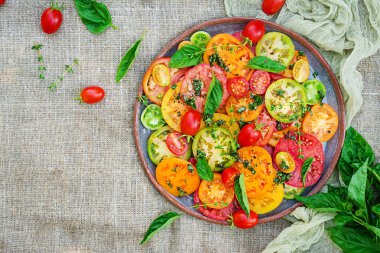 Renkli domates salatası soğan ve fesleğen. Vegan gıda. Üstten görünüm. Düz yatıyordu