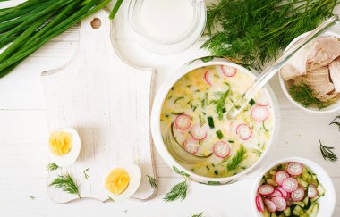 Yumurta, salatalık, tavuk ve ahşap masa üzerine dereotu ile yaz yoğurt soğuk çorba yemek pişirmek için malzemeler. Okroshka. Rus gıda. Üstten görünüm. Düz yatıyordu. Mockup