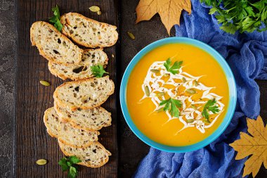 Bir kase kabak çorbası maydanoz ve kabak çekirdeği ile servis. Vegan çorba. Şükran günü yemeği. Cadılar Bayramı yemek. Üstten görünüm