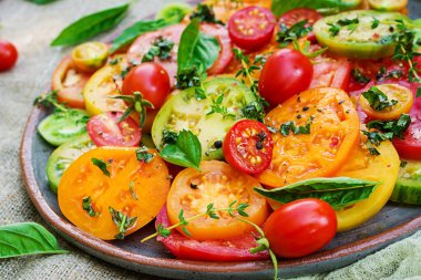 Renkli domates salatası soğan ve fesleğen. Vegan gıda.