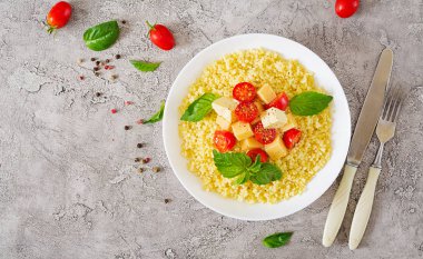 Darı püresi Peynir, tereyağı ve fesleğen beyaz kase. Lezzetli yemekler. Kahvaltı. Üstten görünüm. Düz yatıyordu