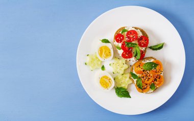 Kahvaltı. Krem peynir ve domates ile krem peynirli sandviç. Üstten görünüm. Düz yatıyordu