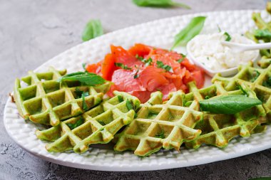 Ispanak ve krem peynir, beyaz tabak içinde somon ile lezzetli waffle. Lezzetli yemekler.