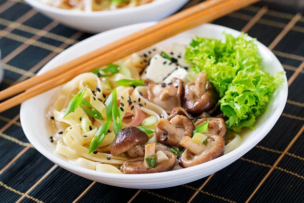 Vegan noodle soup with tofu cheese, shiitake mushrooms and lettuce in white bowl. Asian food. — Stock Image Vegan Noodle Soup Tofu Cheese Shiitake Mushrooms Lettuce White Bowl Stock Picture