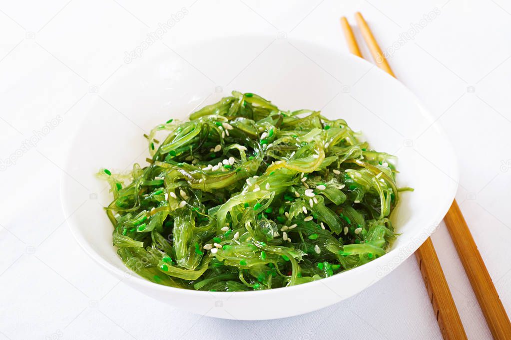Wakame Chuka or seaweed salad  with sesame seeds in bowl on white background. Traditional Japanese food.