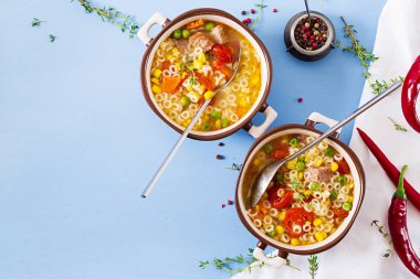 Küçük makarna, sebze ve et mavi masada parçaları ile çorbası