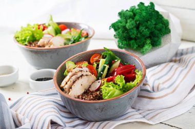 Buda kase tavuk fileto, quinoa, avokado, tatlı biber ve beyaz masa üzerinde çeşitli sebze