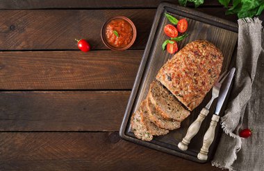 Üstten görünüm lezzetli ev yapımı zemin Türkiye köfte sosu, çatal bıçak takımı ve kopya alanı ile ahşap masa üzerinde pişmiş.