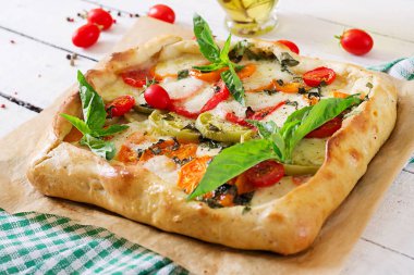 Akdeniz pasta mozzarella peyniri, domates, fesleğen Beyaz ahşap zemin üzerinde. 