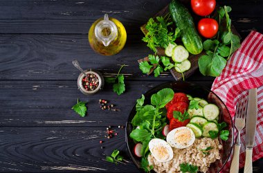 Sağlıklı salata taze sebze - domates, salatalık, turp, yumurta, roka ve yulaf ezmesi kupa. Diyet yemekleri. Düz yatıyordu. Üstten görünüm