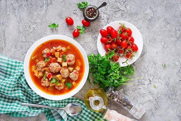 テーブルの上にボウルにミートボールと野菜のクローズ アップと熱いシチュー トマト スープ このスープ スペイン語とメキシコ料理 平面図です フラットを置く — ストック写真
