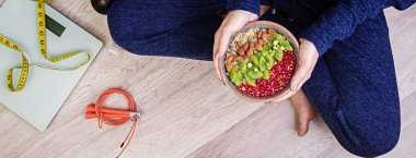 Fitness ve sağlıklı yaşam konsepti. Erkek dinlenme ve bir egzersiz yaptıktan sonra sağlıklı bir yulaf ezmesi yemek. Afiş. Üstten görünüm.