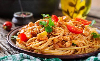Domates soslu spagetti bolonez makarna, sebze ve kıyma - sade ahşap arka planda ev yapımı İtalyan makarnası.