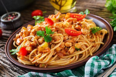 Domates soslu spagetti bolonez makarna, sebze ve kıyma - sade ahşap arka planda ev yapımı İtalyan makarnası.