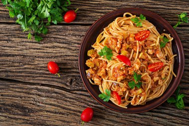 Spagetti bolognese makarna domates sos, sebze ve kıyılmış et - rustik ahşap zemin üzerine ev yapımı sağlıklı İtalyan makarna. Üstten görünüm. Düz yatıyordu
