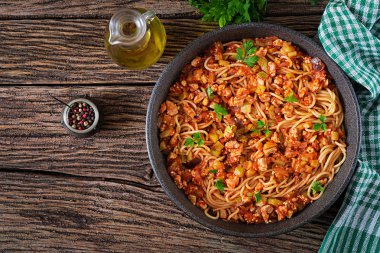 Spagetti bolognese makarna domates sos, sebze ve kıyılmış et - rustik ahşap zemin üzerine ev yapımı sağlıklı İtalyan makarna. Üstten görünüm. Düz yatıyordu