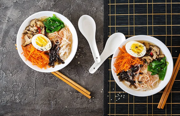 Diet vegetarian bowl of noodle soup of shiitake mushrooms, carrot and boiled eggs