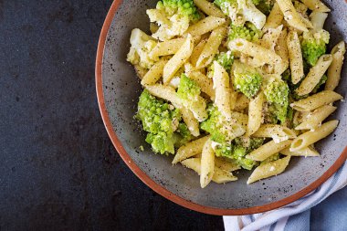 Penne makarna ile lahana romanesco siyah masada. Vejetaryen yiyecekler. İtalyan menüsü. Üstten görünüm. Düz yatıyordu