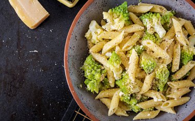 Penne makarna ile lahana romanesco siyah masada. Vejetaryen yiyecekler. İtalyan menüsü. Üstten görünüm. Düz yatıyordu