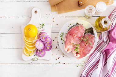 Çiğ biftek sazan balık limon ve beyaz ahşap zemin üzerine kekik. Balık parşömen kağıt kavurma için hazırlanıyor. Diyet menüsü. Üstten görünüm. Düz yatıyordu