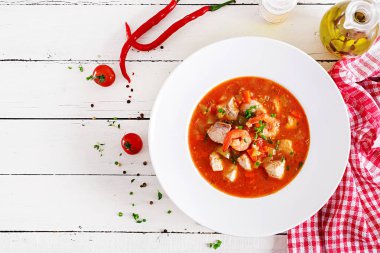 Brezilya gıda: balık ve biber baharatlı Hindistan cevizi soslu Beyaz ahşap bir masa üzerinde bir tabak içinde Moqueca capixaba. Brezilyalı balık güveç. Üstten görünüm